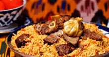 a plate of food with rice , meat , and garlic on a table .