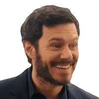 a man with a beard is smiling with his teeth showing