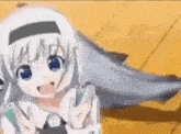 a girl with white hair and blue eyes is sitting on a wooden floor .