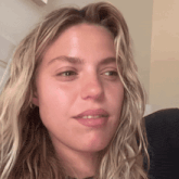 a close up of a woman 's face with a slight smile