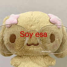 a stuffed animal wearing glasses with the words `` soy esa '' written in red .