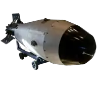 a large bomb is sitting on wheels on a stand