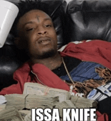 a man is laying on a couch holding a stack of money with the caption " issa knife "