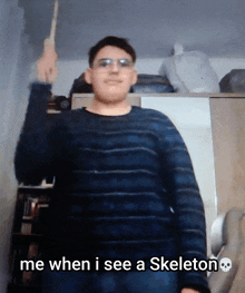 a man in a striped sweater holds up a wand and says me when i see a skeleton