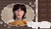 a young woman wearing glasses is holding a teddy bear in front of a chocolate bar .