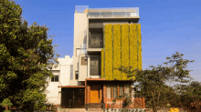 a tall building with a green wall on the side of it