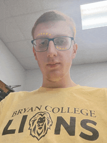 a man wearing glasses and a yellow bryan college lions t-shirt