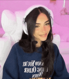 a woman wearing headphones and a blue sweatshirt with the word order on it .