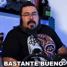 a man with a beard and glasses is wearing a black shirt that says bastante bueno .