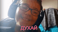 a boy wearing glasses and headphones is smiling with the word " duhai " written in red letters