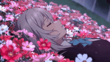 a girl is laying in a field of pink flowers .