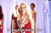 a blonde woman in a red dress is holding a microphone and says i believe in the word equality