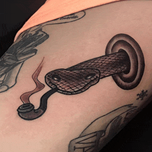 a tattoo of a snake with a smoke coming out of its mouth