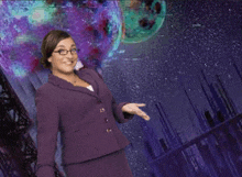 a woman wearing glasses and a purple suit is standing in front of a purple background