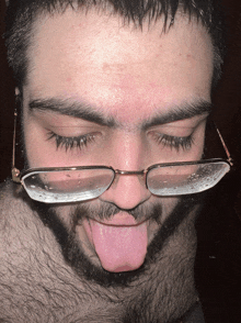 a man with glasses sticking out his tongue