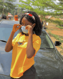 a woman wearing a mask and a yellow shirt that says nasa