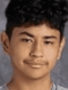 a close up of a young man 's face with a gray background .