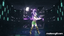 a woman in a green dress and gold boots is dancing on a stage in a dark room .