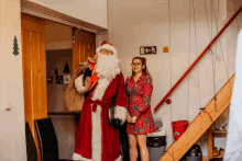 a man dressed as santa claus stands next to a woman