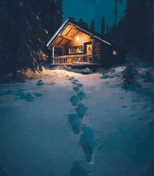 footprints in the snow lead to a log cabin