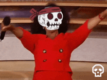 a woman wearing a skull mask is holding a microphone in her hand .