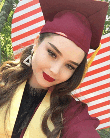 a woman wearing a graduation cap and gown poses for a picture