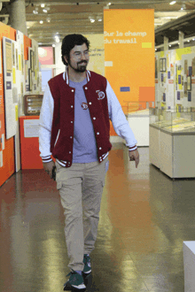 a man walking in a hallway with a sign that says sur la champ du travail