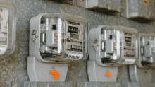 several electrical meters are lined up on a wall and one of them has a sticker on it that says 88197426