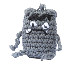 a knitted monster with a sad face and a bat on its head