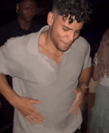 a man with curly hair is dancing in a dark room