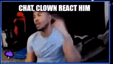 a man in a blue shirt is sitting in front of a screen with the words `` chat , clown react him '' on it .