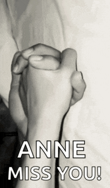 a black and white photo of two people holding hands with the words anne miss you