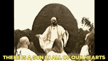 a man in a white robe is sitting in front of a group of people in front of a large sculpture .