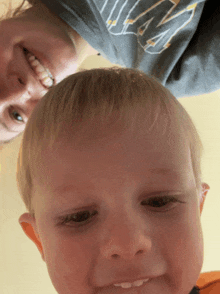 a woman wearing a nike shirt is smiling next to a child