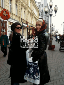 two women walking down a street with amber negra russia written on the top