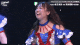 a woman in a blue and red dress is laughing in front of a sign that says jpw