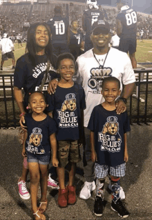 a man and three children wearing big blue kids club shirts