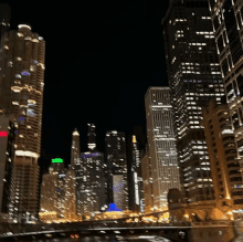 a blurry picture of a city skyline at night with a green sign that says ' chase '