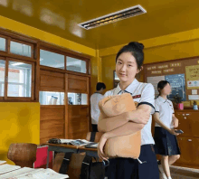 a girl in a school uniform holds a stuffed animal