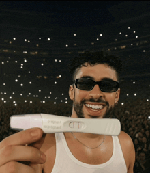a man holding a pregnancy test that says pregnant not pregnant