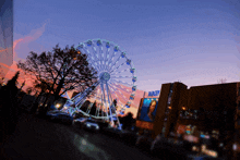 a ferris wheel is in front of a building that says night