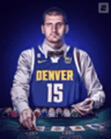 a man wearing a denver 15 jersey is playing poker .