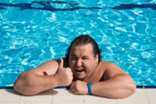 a shirtless man is giving a thumbs up in a pool