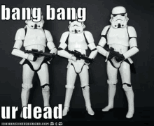 three stormtroopers are standing next to each other and holding guns in a black and white photo .