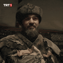 a man with a beard wearing a fur hat with trt1 written on the bottom