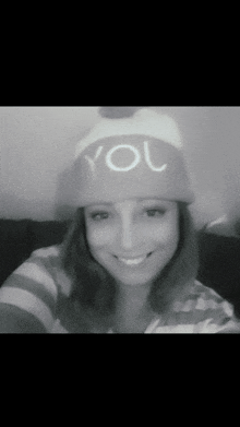 a woman wearing a hat that says you is smiling