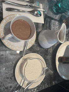 a cup of hot chocolate sits on a saucer on a table