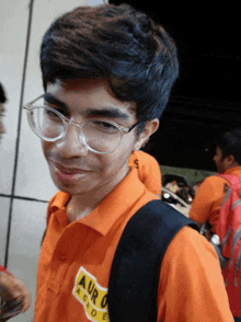 a young man wearing glasses and a shirt that says aur academy