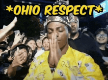 a man wearing a crown prays in front of a crowd with the words ohio respect above him