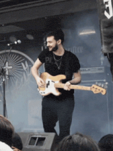 a man playing a guitar with a shirt that says pl
